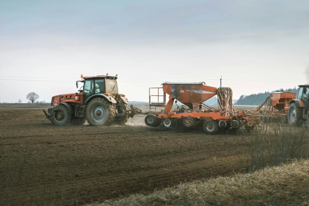 Tractors working in a rural field using advanced machinery for sowing and Strip-Till techniques.
