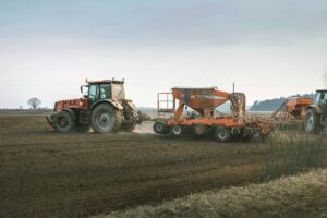 Tractors working in a rural field using advanced machinery for sowing and Strip-Till techniques.