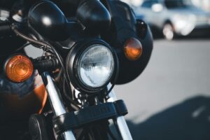 Detailed view of a classic motorcycle headlight with chrome features outdoors.