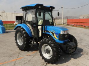 Modern blue 4WD tractor parked outdoors on a sunny day in India.