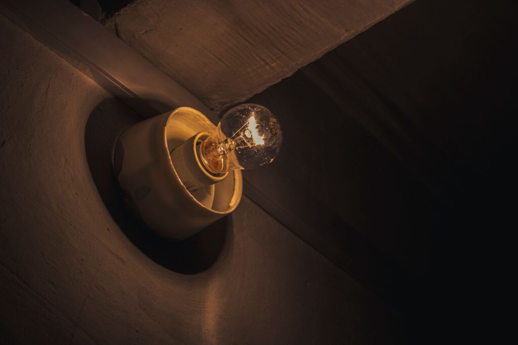 Close-up of a glowing light bulb casting a warm hue, emphasizing vintage simplicity.