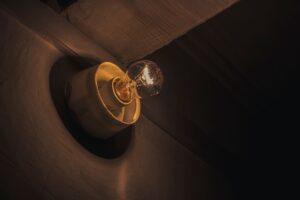 Close-up of a glowing light bulb casting a warm hue, emphasizing vintage simplicity.